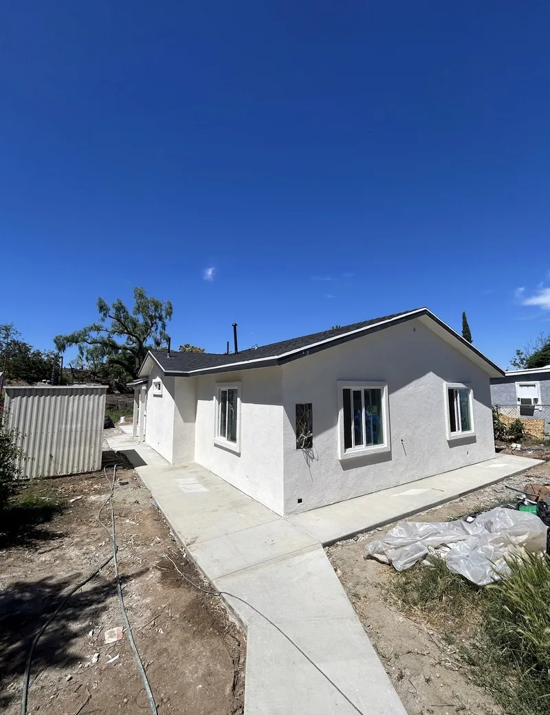 Completed ADU exterior with stucco finish and concrete walkway
