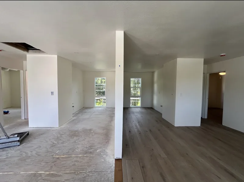 Open living area with hardwood flooring being installed