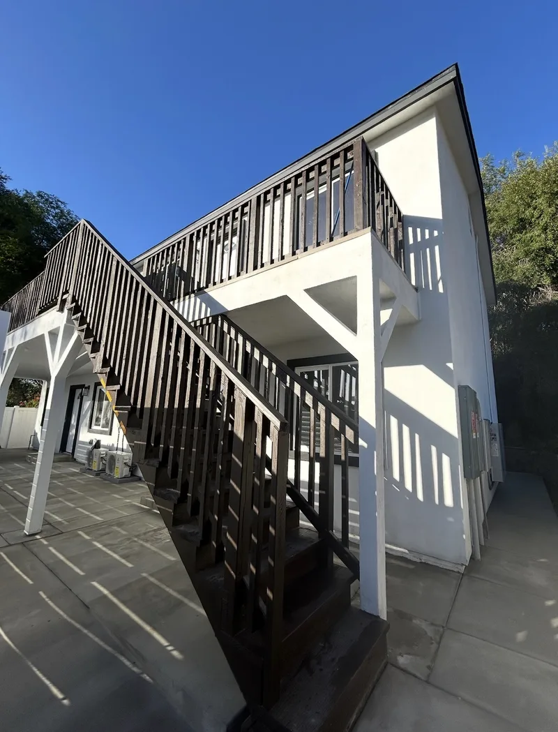 Two-story ADU with exterior staircase and dark trim